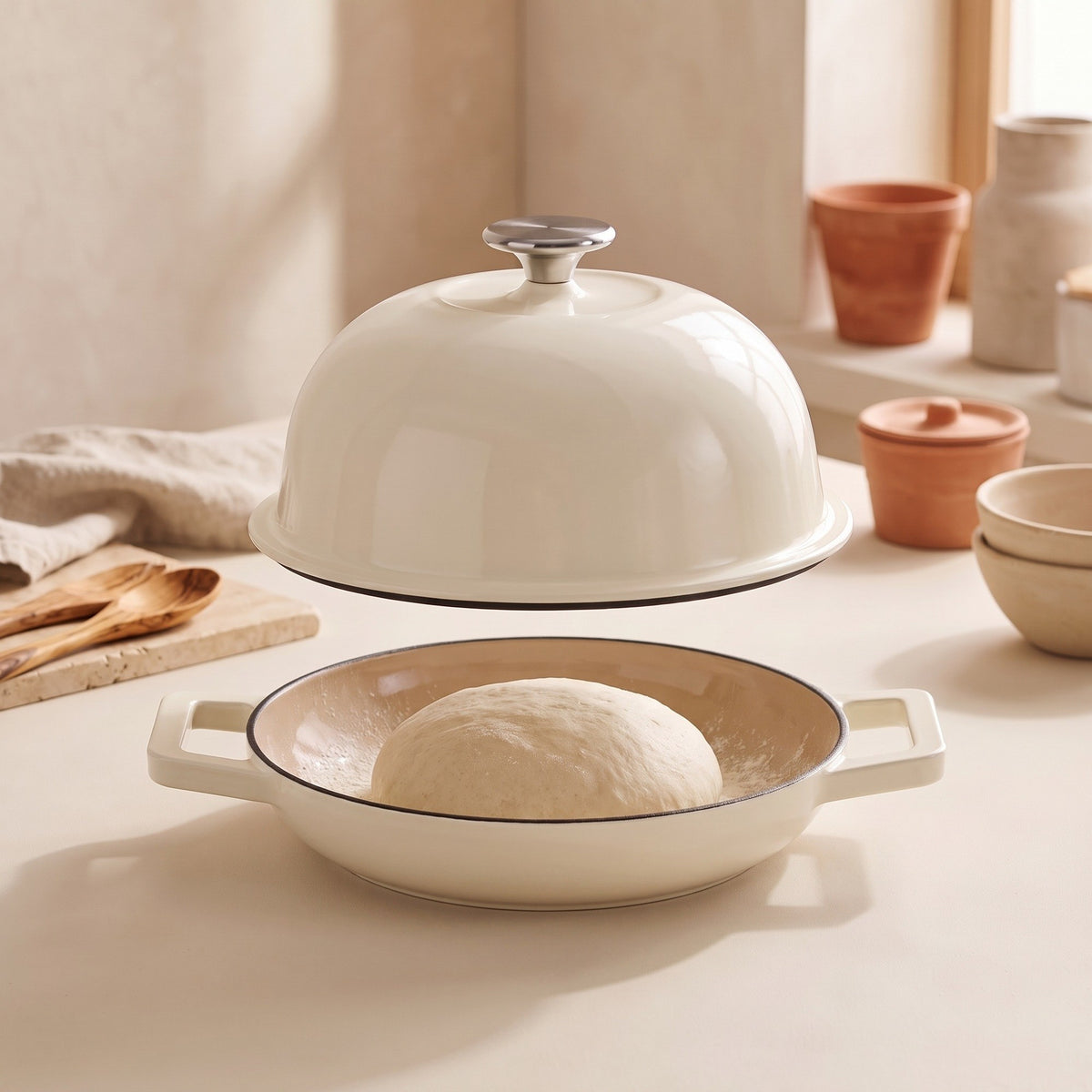Cúpula en alto y bola de masa sobre la base del horno de pan, en una encimera clara